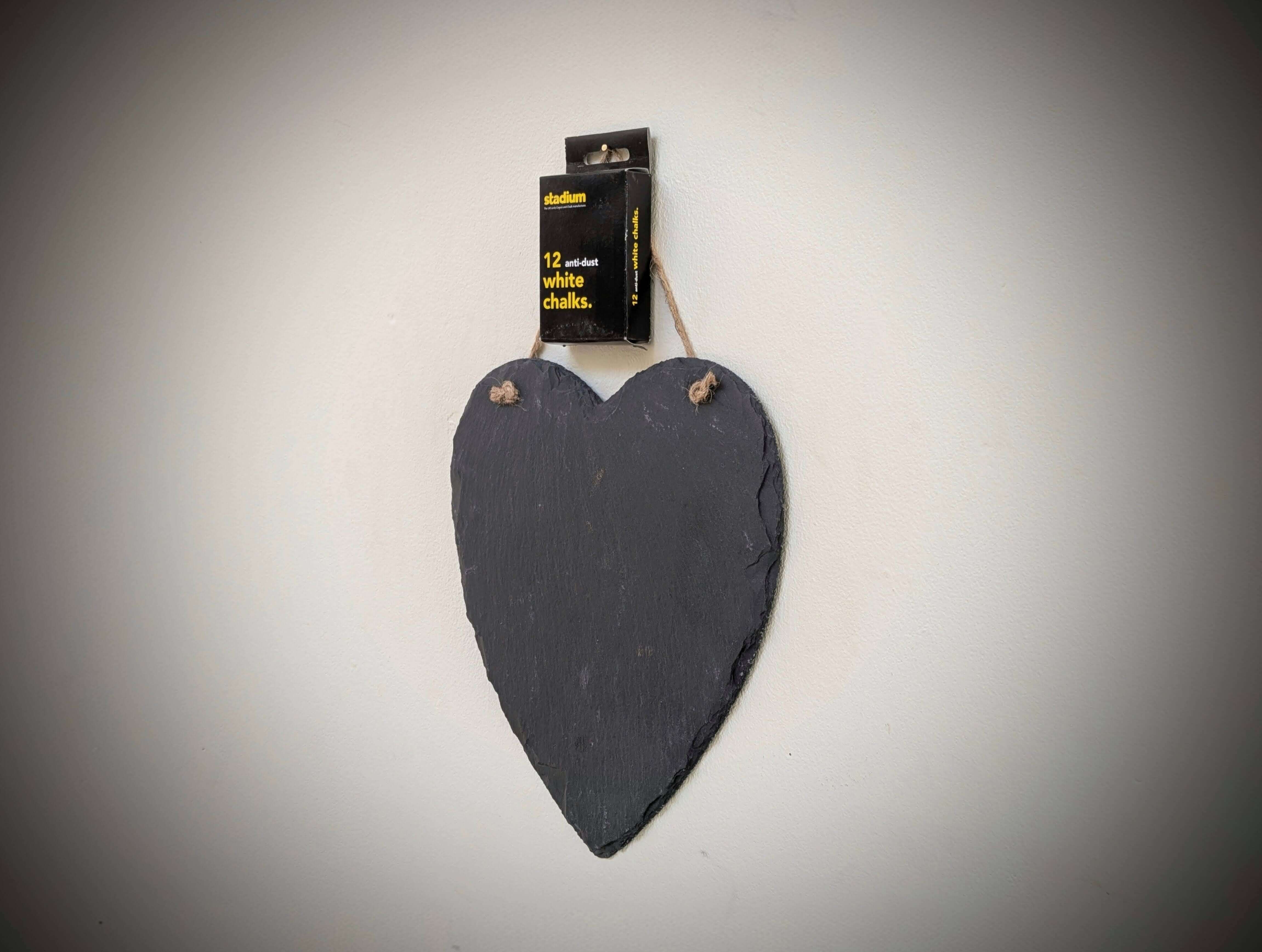 Heart-shaped slate board with a packaging label on a gray background