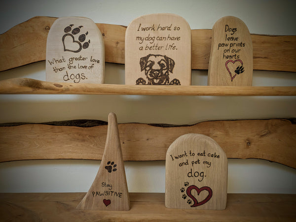 Dog pyrography (woodburning) quotes on wooden blocks and wall hangings.
